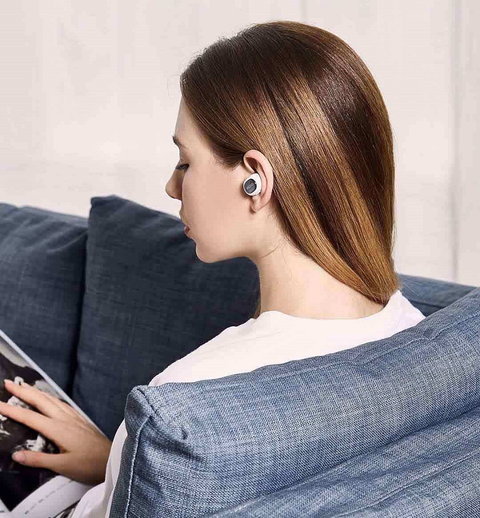 Bluetooth headset QCY Q26 дівчина з гарнітурою за читанням каталогу