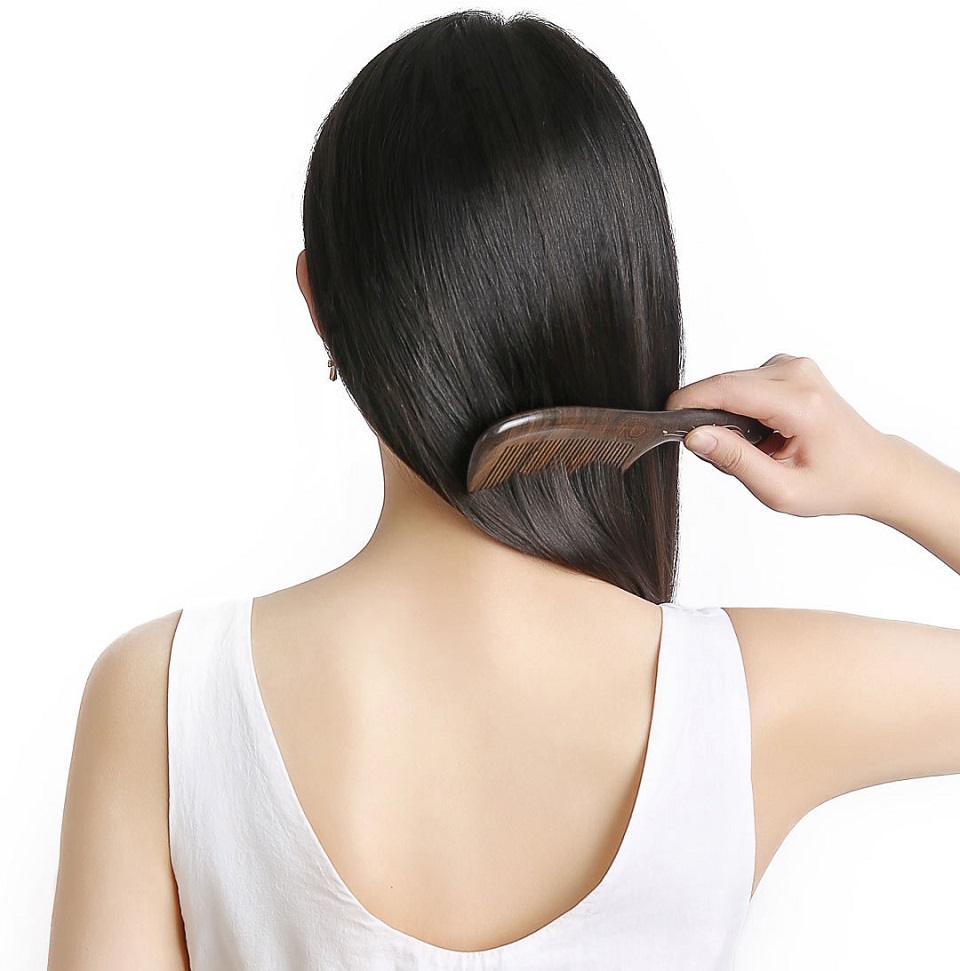 Деревянная расческа для волос XinZhi Ebony в руках пользователя