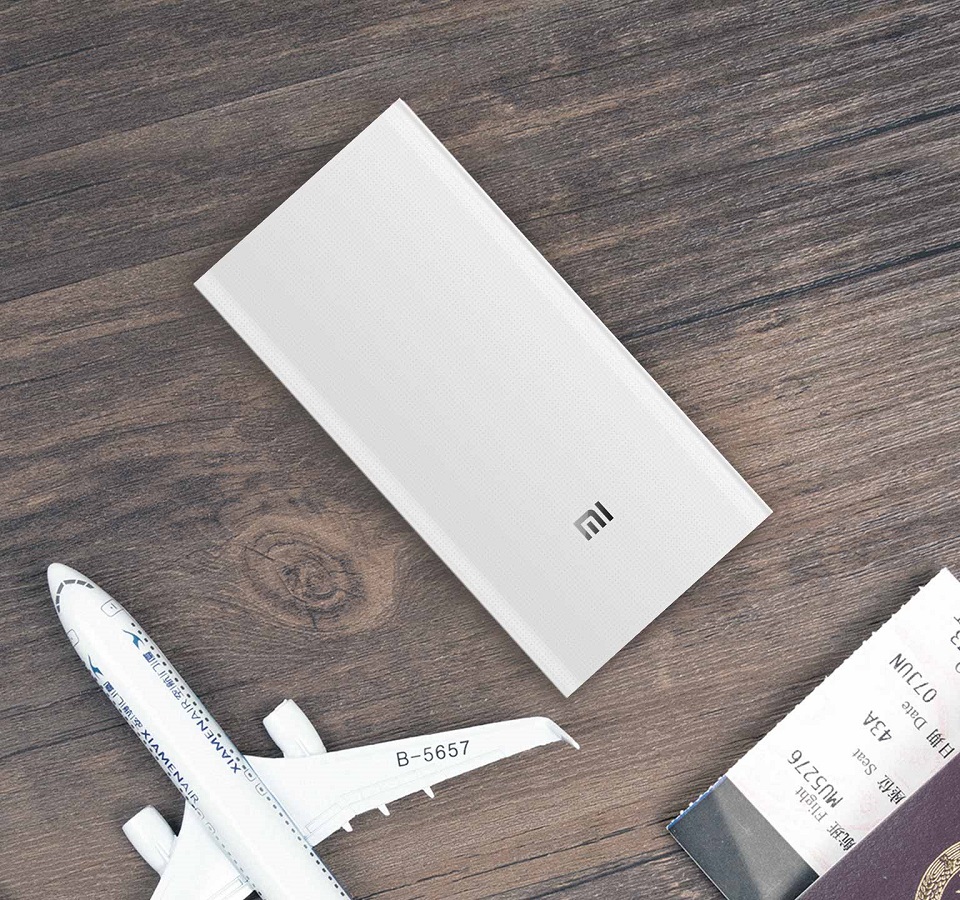 Универсальная батарея Xiaomi Mi power bank 2 White 20000mAh на столе рядом с самолетом